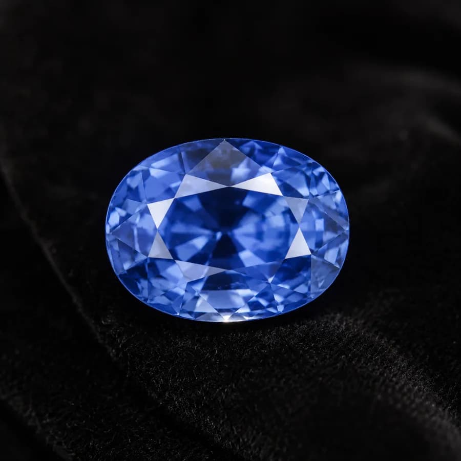 Faceted oval Ceylon sapphire from Sri Lanka in bright medium blue, face-up on black velvet